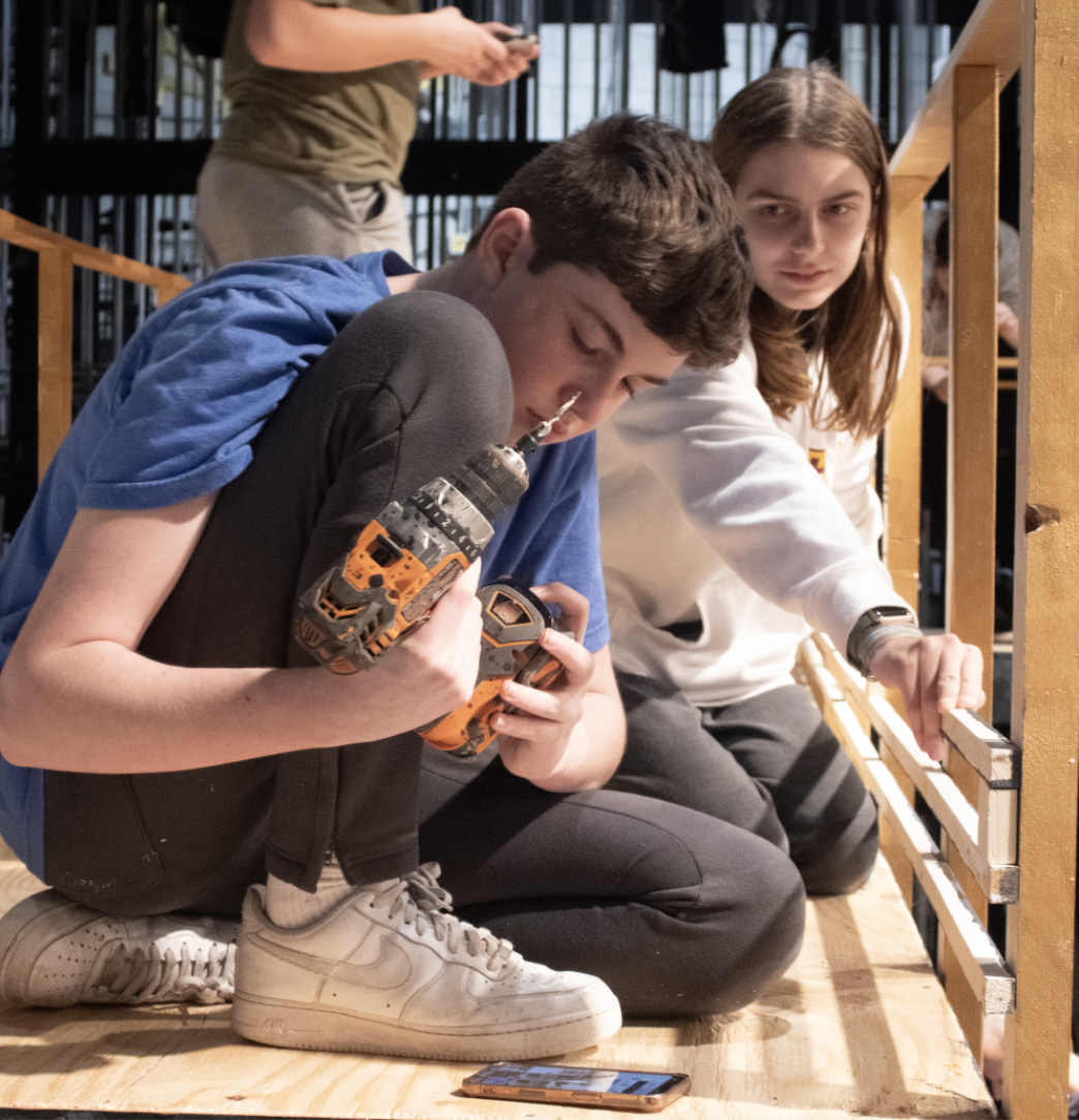 CREW COLLAB: Senior Josh Footlik, North Stage Crew member, and sophomore Savannah Stec, South Stage Crew member, work together to build the set for Chicago. Students from both schools help out with stage construction. 